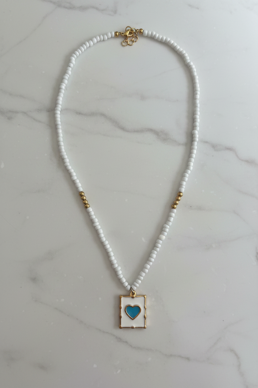 Beaded Blue Heart Necklace on marble background